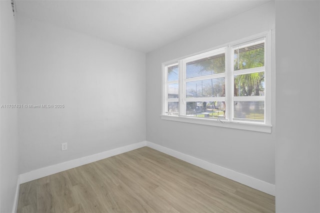 spare room with light wood-style flooring and baseboards