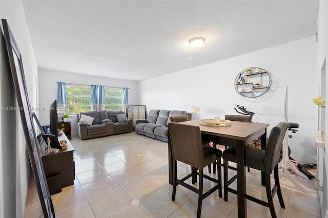 dining space with a textured ceiling and light tile patterned floors