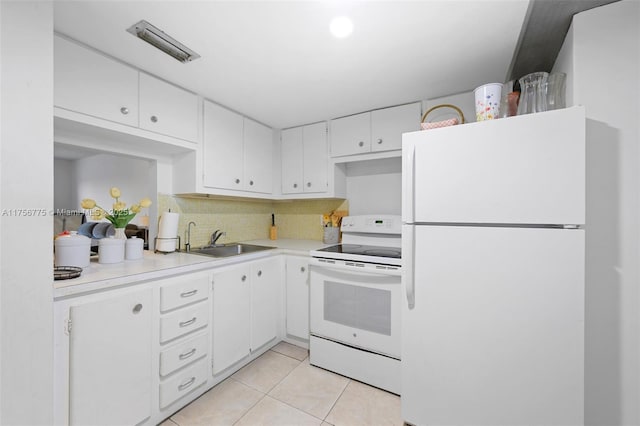 kitchen featuring white appliances, light tile patterned floors, white cabinets, light countertops, and a sink