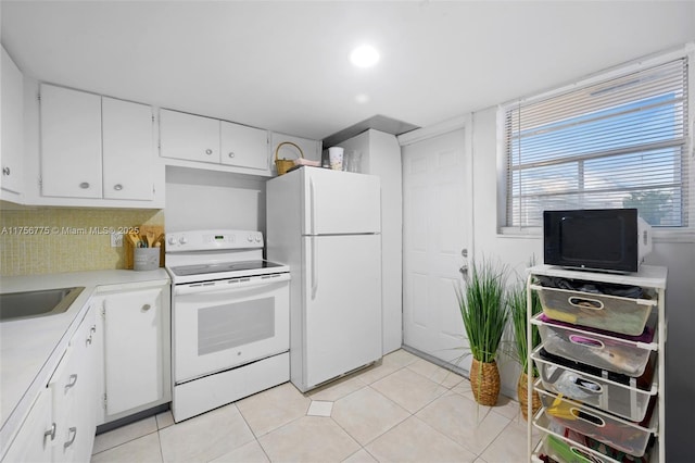 kitchen with light tile patterned floors, white appliances, white cabinets, light countertops, and backsplash