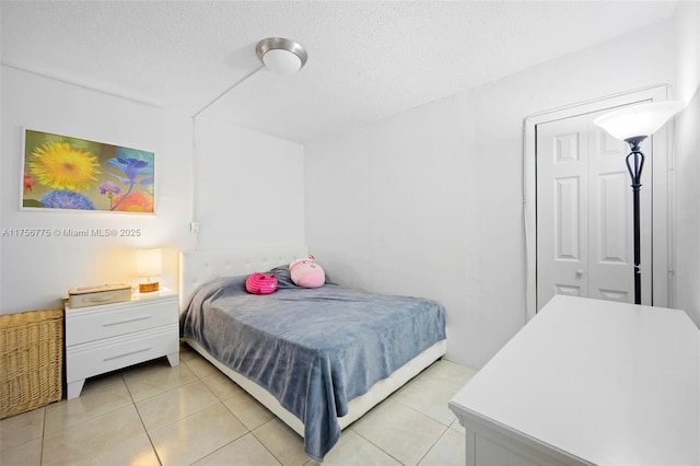 bedroom featuring light tile patterned floors and a textured ceiling