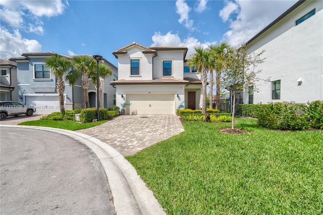 view of front of property featuring decorative driveway, a tile roof, stucco siding, a front yard, and a garage