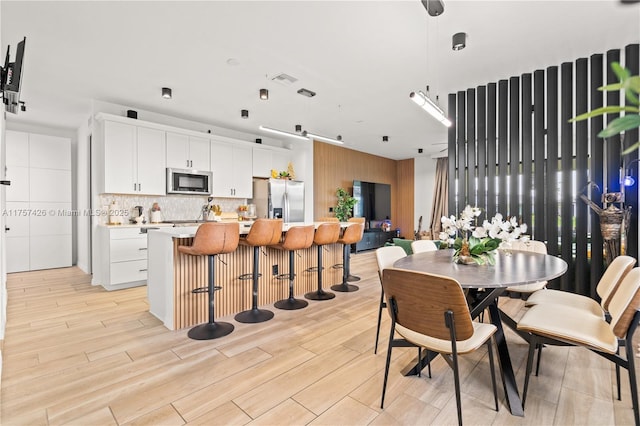 dining space featuring visible vents and light wood-style flooring