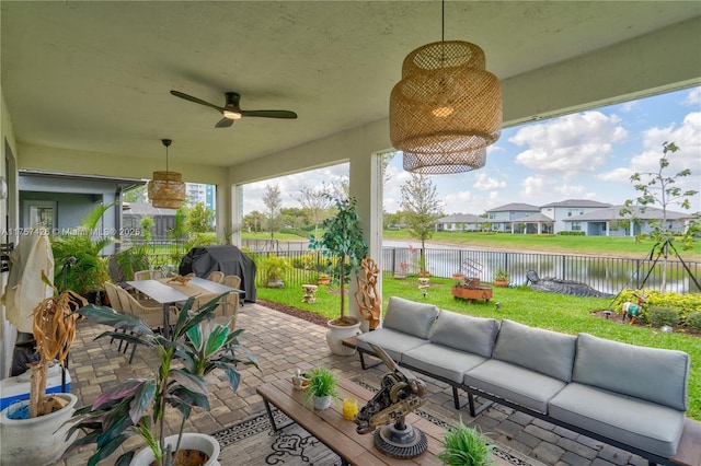 view of patio / terrace featuring outdoor dining area, a fenced backyard, a water view, an outdoor living space, and a ceiling fan