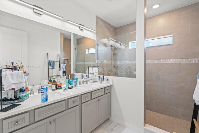 full bath featuring a sink, marble finish floor, double vanity, and walk in shower