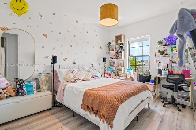 bedroom featuring arched walkways and wood finished floors