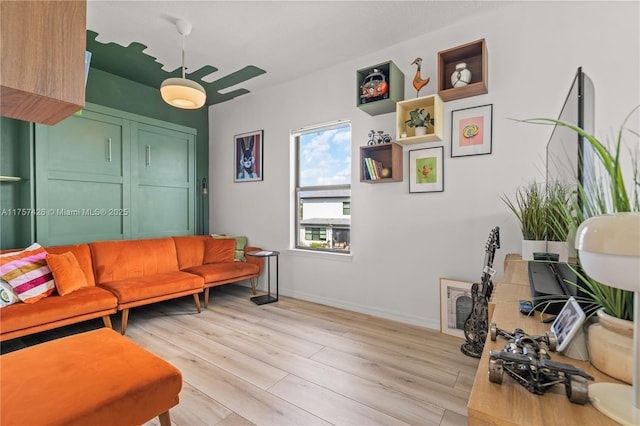 living area featuring light wood finished floors, visible vents, and baseboards