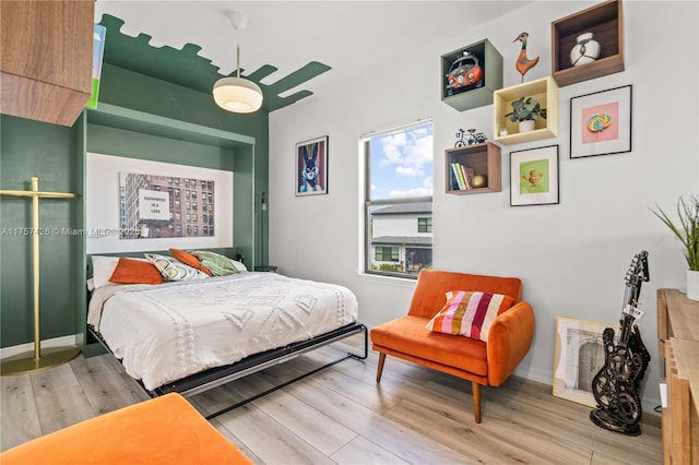 bedroom featuring light wood-style floors, ceiling fan, and baseboards