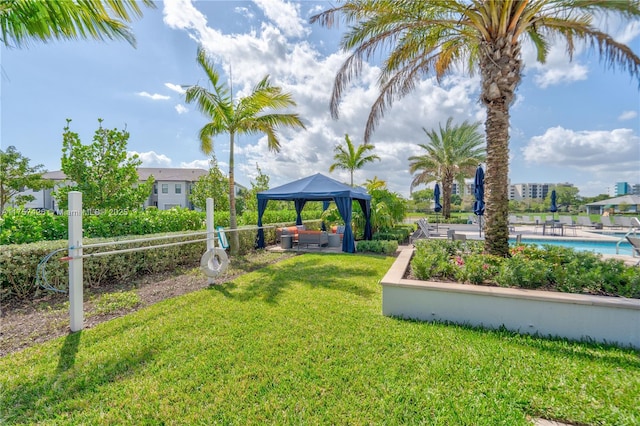 exterior space with a gazebo, a lawn, fence, and a pool