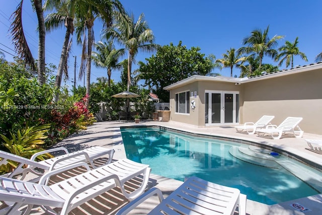 view of pool with a fenced in pool, french doors, a patio, and fence