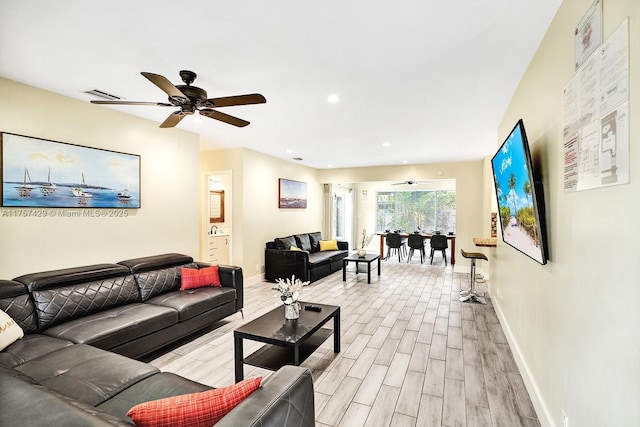 living area featuring recessed lighting, baseboards, ceiling fan, and light wood finished floors