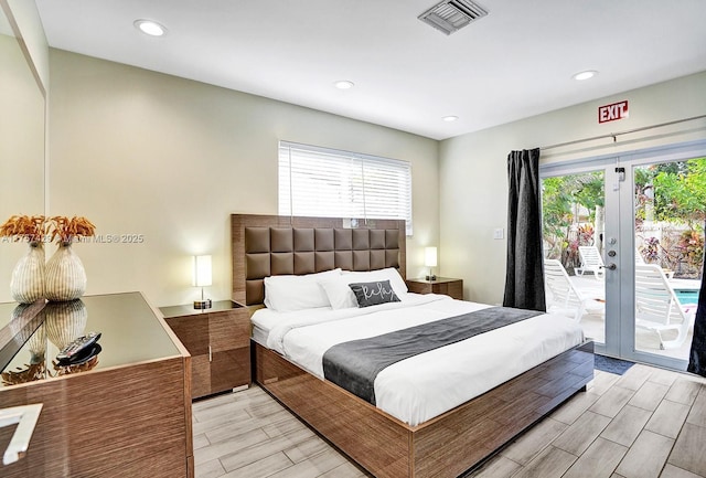 bedroom featuring wood finish floors, multiple windows, visible vents, and access to exterior