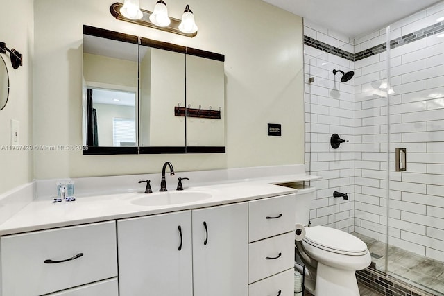 full bath featuring toilet, a shower stall, and vanity