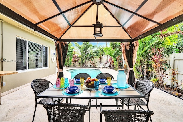 view of patio / terrace featuring a gazebo, a fenced in pool, a fenced backyard, and outdoor dining space