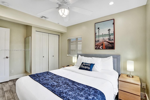 bedroom featuring a closet, visible vents, ceiling fan, wood finished floors, and baseboards