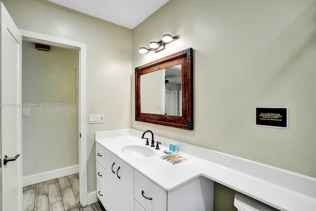 bathroom featuring wood finish floors, vanity, and baseboards