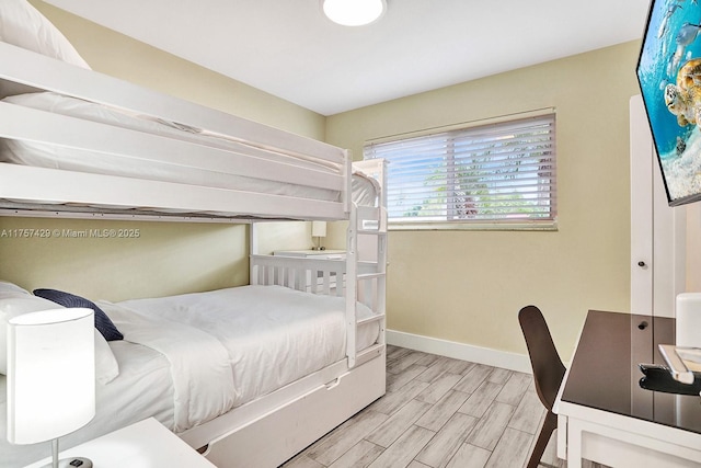 bedroom with baseboards and wood finished floors