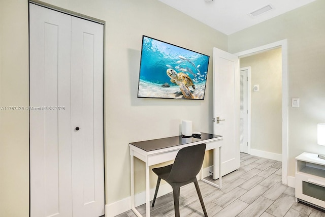 office area featuring wood finish floors, visible vents, and baseboards