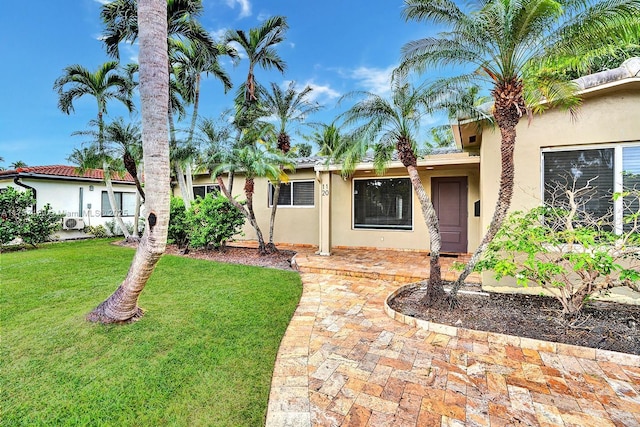 view of front of property with a front yard and stucco siding