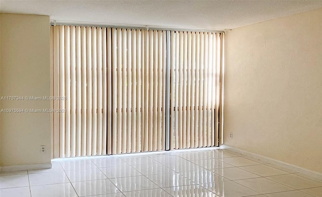 unfurnished room featuring tile patterned flooring and baseboards