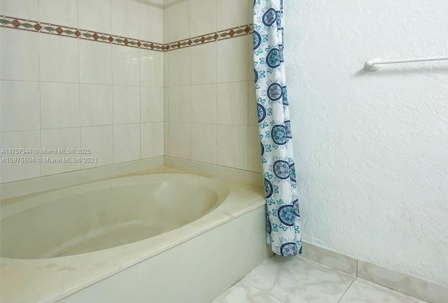 bathroom featuring a textured wall and tile patterned floors