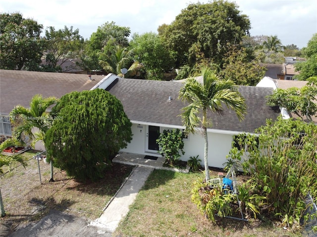 view of front of home with a shingled roof and stucco siding