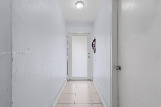 hallway with baseboards and light tile patterned floors