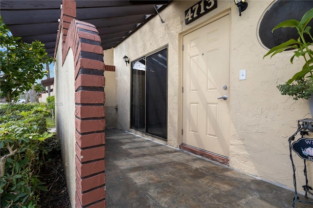 doorway to property with stucco siding