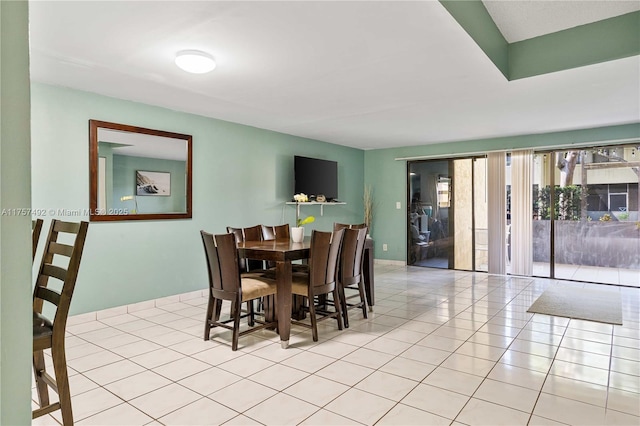 tiled dining area featuring baseboards