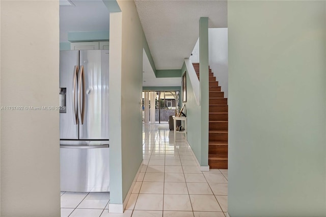 hall with light tile patterned flooring and stairway