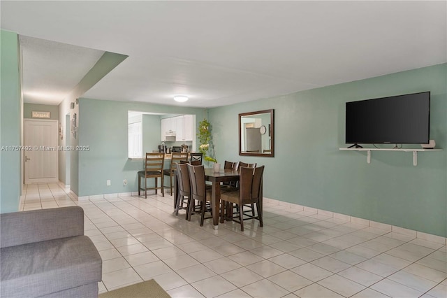 dining area featuring light tile patterned floors and baseboards