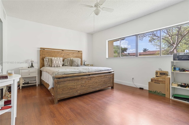 bedroom featuring a ceiling fan, a textured ceiling, baseboards, and wood finished floors