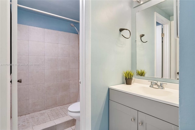 bathroom with toilet, a stall shower, and vanity