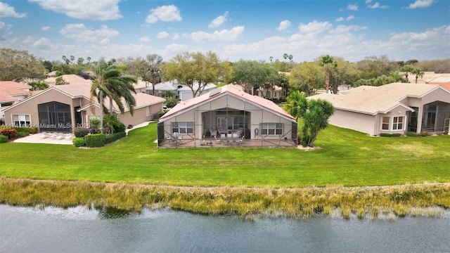 back of house with a yard, a water view, a lanai, and a residential view