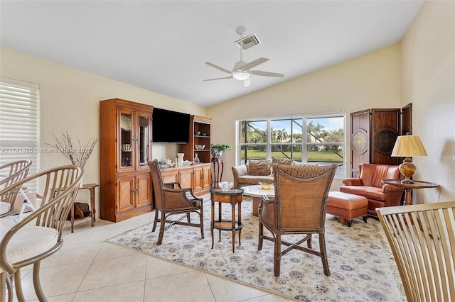 living area with a ceiling fan, lofted ceiling, visible vents, and light tile patterned floors