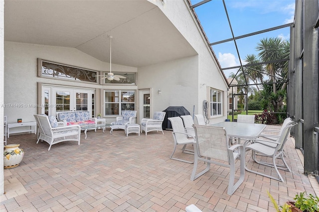 view of patio with glass enclosure, french doors, and a ceiling fan