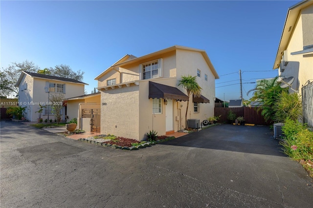 view of front of property featuring stucco siding, fence, and central air condition unit