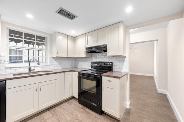 kitchen featuring tasteful backsplash, visible vents, black electric range, under cabinet range hood, and a sink