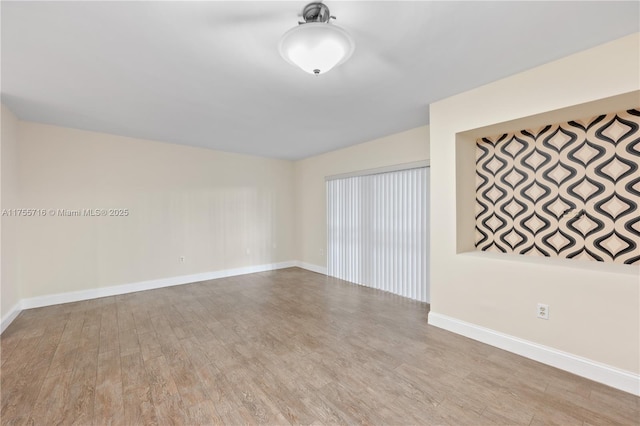 empty room featuring baseboards and wood finished floors