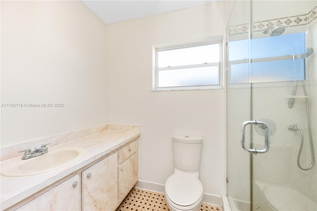 bathroom with toilet, a shower stall, baseboards, and vanity