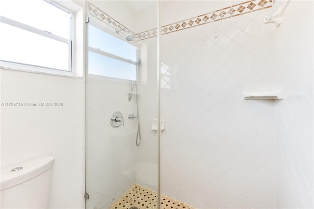 full bathroom featuring a stall shower and toilet