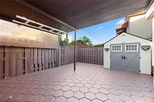 view of patio / terrace with a shed, an outdoor structure, and a fenced backyard