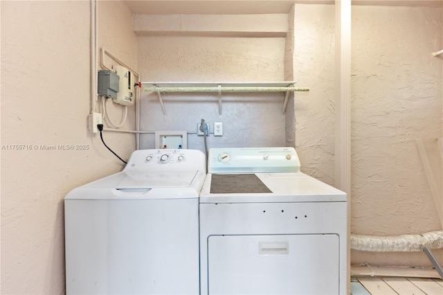 laundry area with washer and dryer, laundry area, and a textured wall