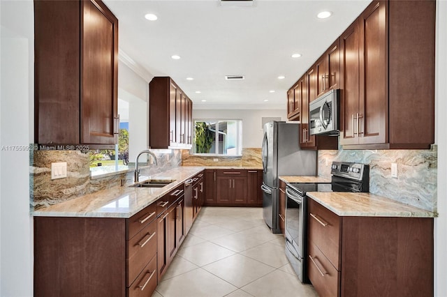 kitchen with light stone counters, light tile patterned flooring, a sink, ornamental molding, and appliances with stainless steel finishes