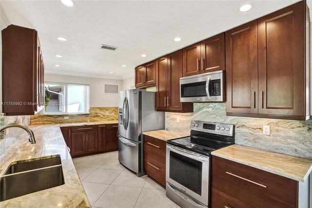 kitchen with light stone counters, light tile patterned floors, visible vents, appliances with stainless steel finishes, and a sink