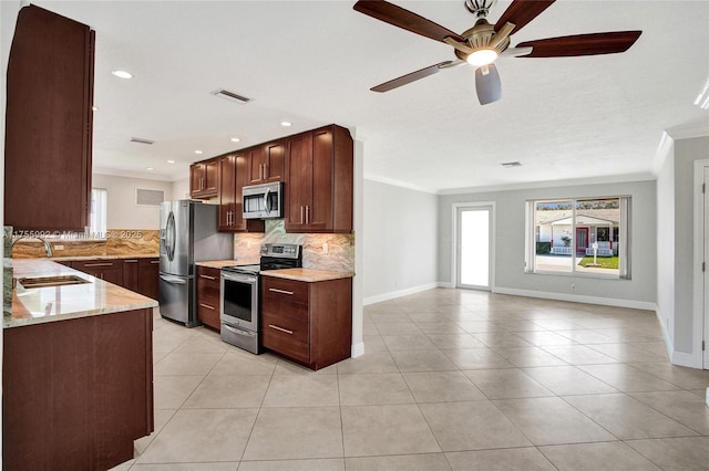 2927 NW 46th St, Tamarac, FL 33309 - kitchen with stainless steel appliances, crown molding, a sink, decorative backsplash, and baseboards