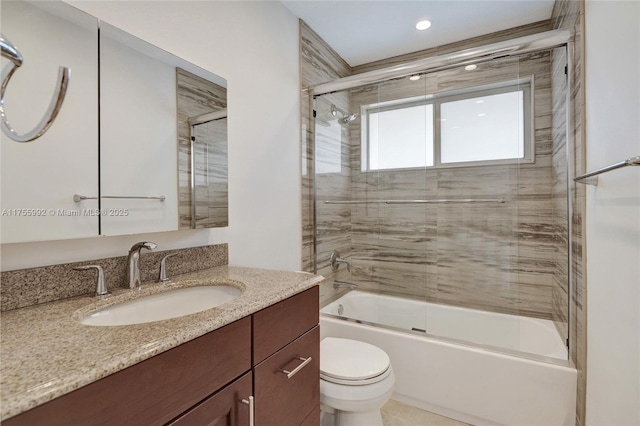 full bathroom with combined bath / shower with glass door, vanity, and toilet