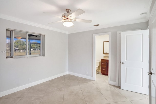 spare room featuring light tile patterned floors, baseboards, visible vents, and crown molding