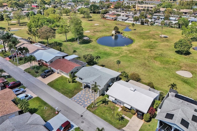 aerial view with a residential view, view of golf course, and a water view