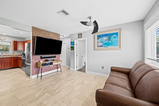 living room featuring baseboards, visible vents, and a ceiling fan